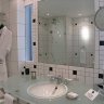 La salle de bain bénéficie de la lumière du jour grâce à deux fenêtres (dont les vitres s'opacifient à la demande) qui donnent sur le coin bureau.
