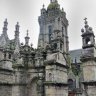 Enclos paroissial de Saint-Thégonnec - La porte triomphale (ou arc de triomphe) de style Renaissance et derrière la tour - également Renaissance- de l'église Notre-Dame 