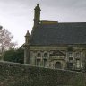 Enclos paroissial de Guimiliau - la chapelle funéraire (1648). Sa façade est ornée de colonnes, de quatre petites baies. Dans une de ces baies, une chaire extérieure a été aménagée.