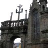 Enclos paroissial de Lampaul-Guimiliau - la porte triomphale (1669) ornée d'un premier calvaire qui présente un Christ en croix entouré de la Vierge Marie et de saint Jean.