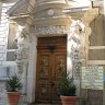 La Villa Lumière, l'entrée principale (rue de Clermont), encadrée par 2 atlantes. La porte est ornée de deux bas-reliefs en bronze, en imposte un troisième bas-relief présente des « Putti » (des petits amours) faisant du cinéma.