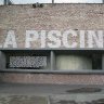 Derrière cette façade, la librairie boutique installée dans l'ancienne salle des filtres de la piscine mérite une visite car les installations ont été conservées, d'où cette structure en béton cylindrique qu'on aperçoit derrière la baie vitrée.